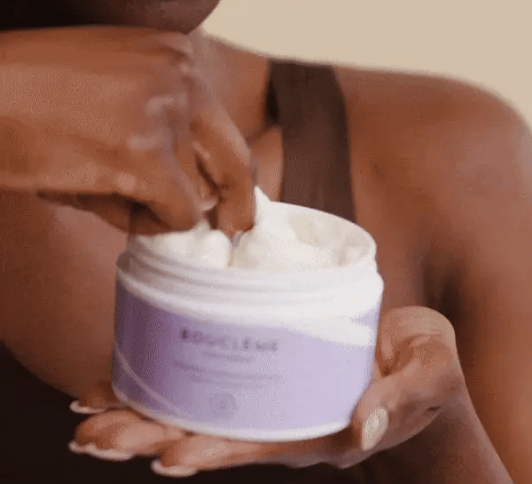 Femme aux cheveux bouclés appliquant le Masque Hydratant Bouclème pour nourrir et sublimer ses boucles naturelles.