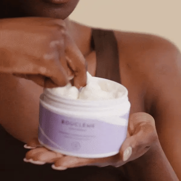 Femme aux cheveux bouclés appliquant le Masque Hydratant Bouclème pour nourrir et sublimer ses boucles naturelles.